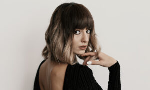 Stylish woman with a sleek bob haircut posing confidently in modern fashion.